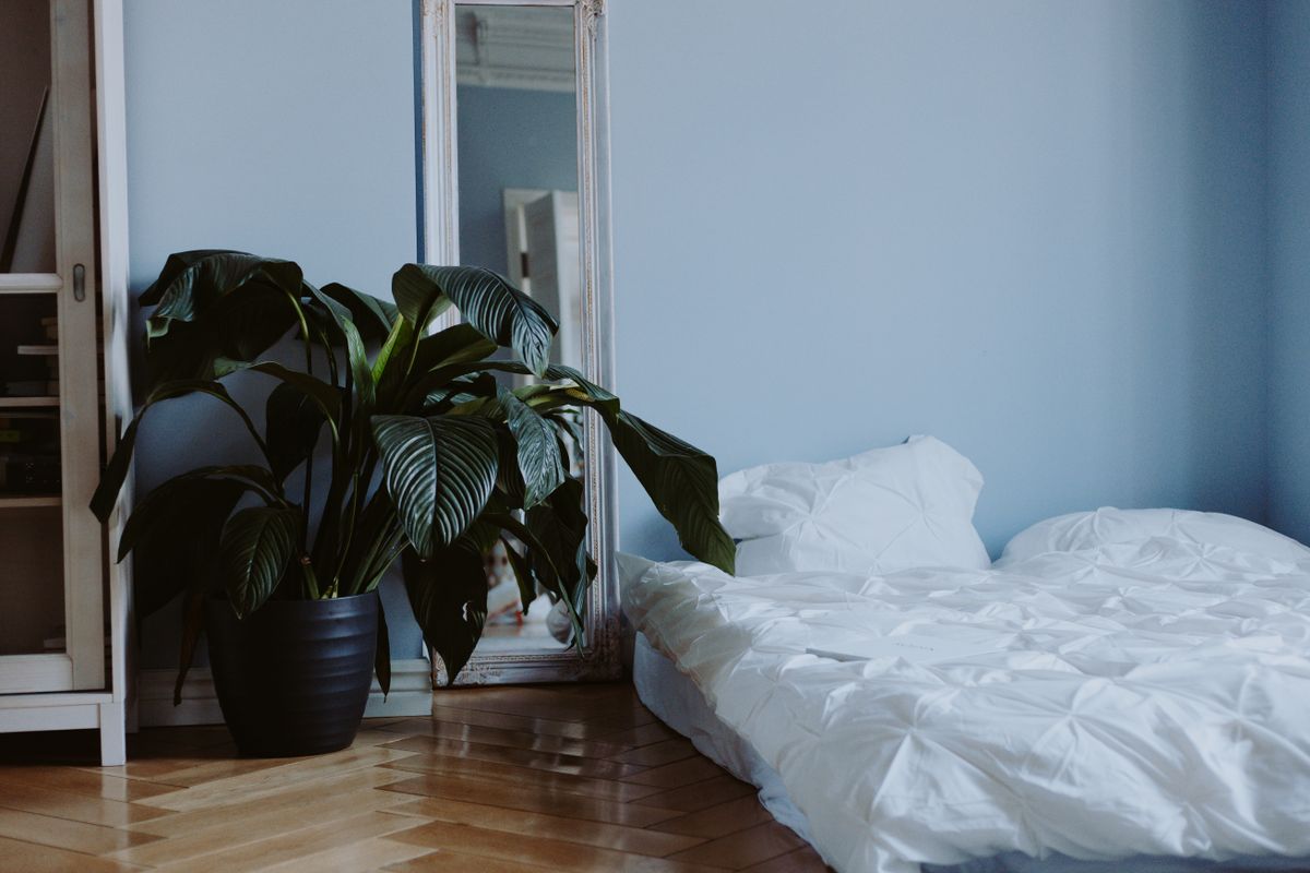 Full-length leaning mirror as a safer alternative to hanging a mirror above the bed Full-length mirror leaning against a bedroom wall as a safer alternative to a mirror above the bed