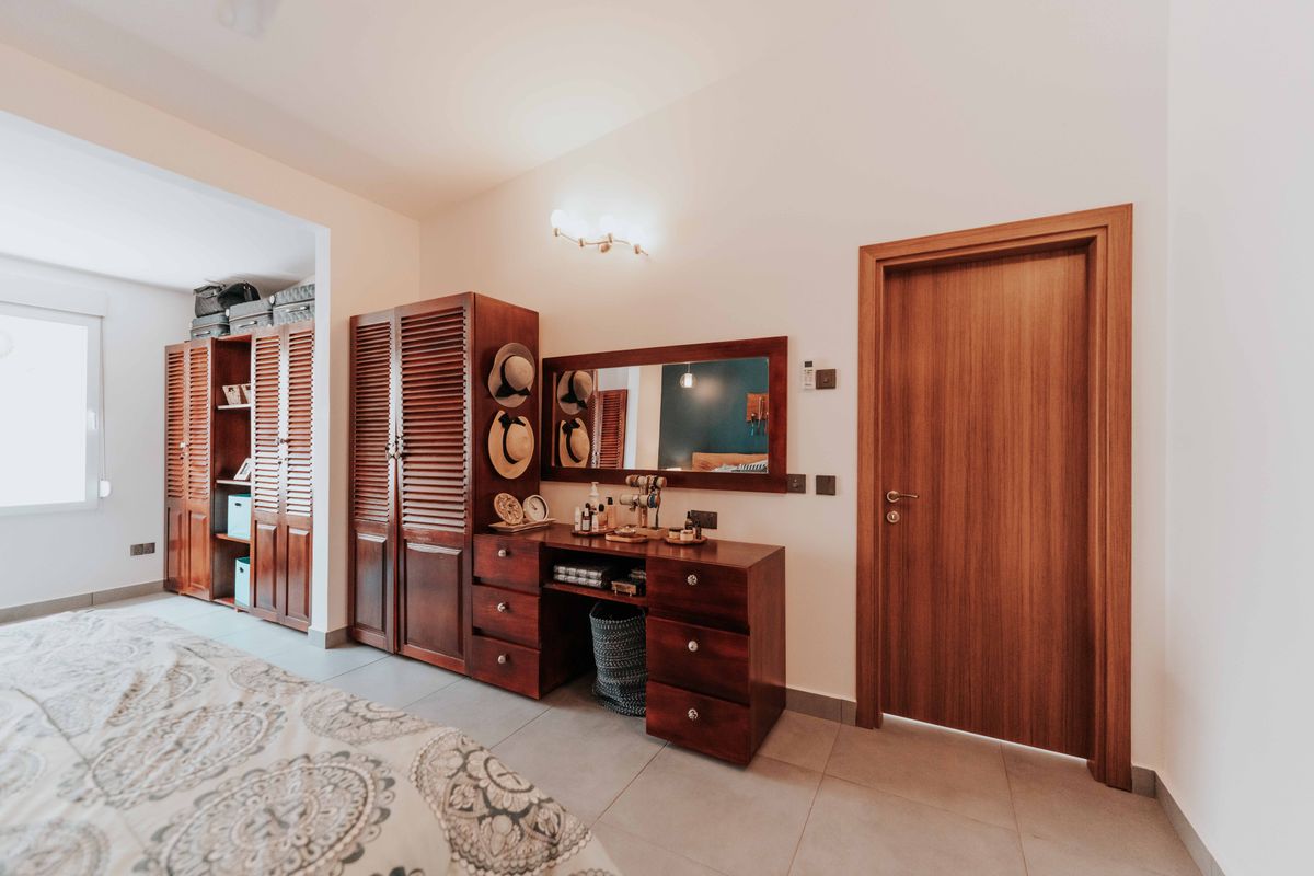 Bedroom with wooden furniture and a mirror illustrating wood mirror frames used room by room Warm, inviting bedroom with elegant wooden furniture and a mirror, illustrating wood mirror frames room by room