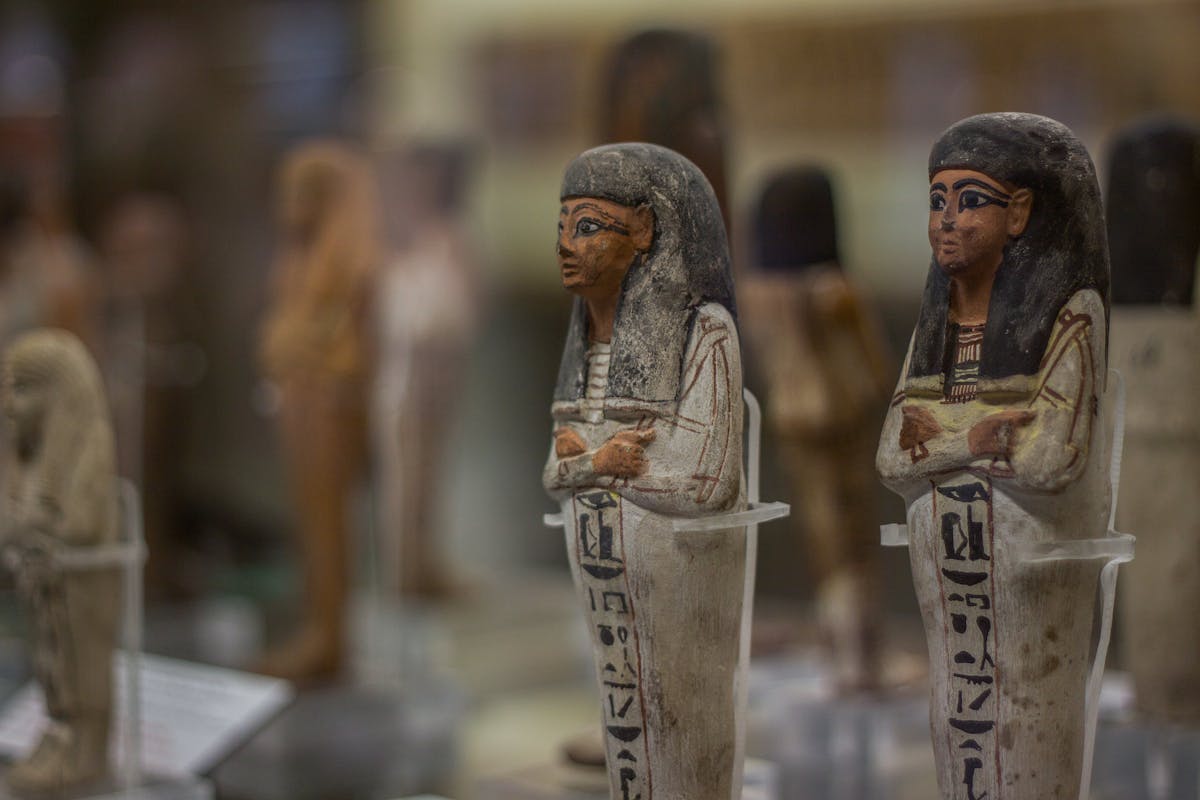 Egyptian artifacts at the Turin museum evoking the sacred objects of Hathor worship and mirror ritual in ancient Egypt Ancient Egyptian figurines on display at the Turin museum representing the artifacts and religious objects connected to Hathor and mirror ritual