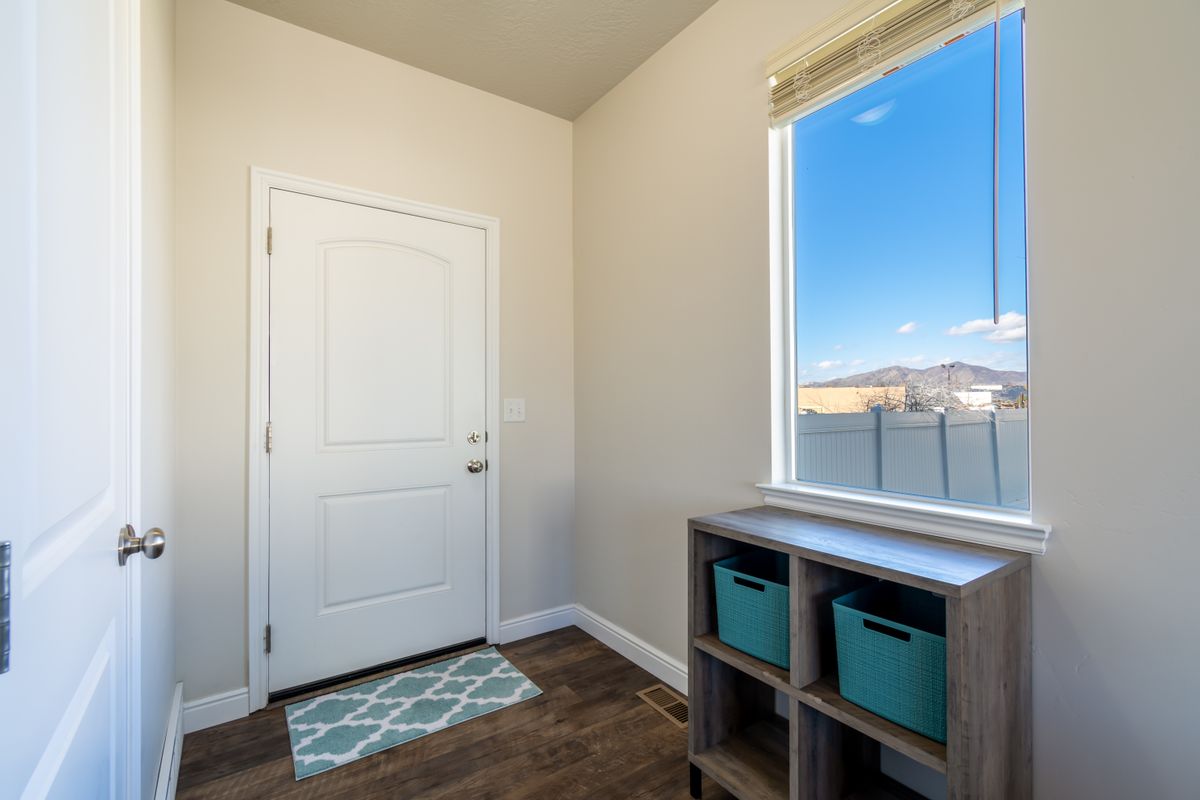 Contemporary entryway with a shelf and natural light, comparing mirror with hooks to mirror with shelf and hooks