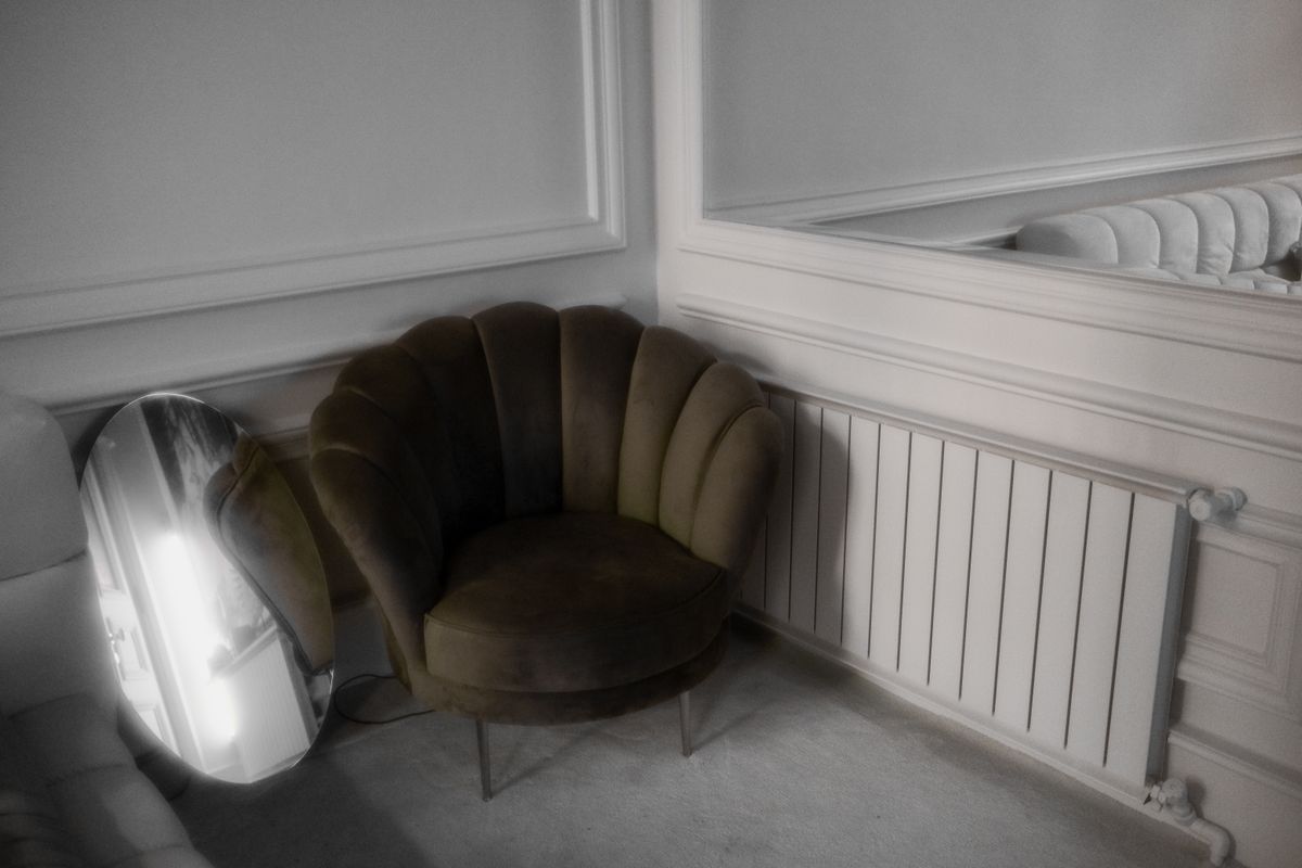 Leaning floor mirror reflecting a room illustrating a living room floor mirror idea Stylish room corner with a large decorative floor mirror reflecting the decor, illustrating a leaning floor mirror