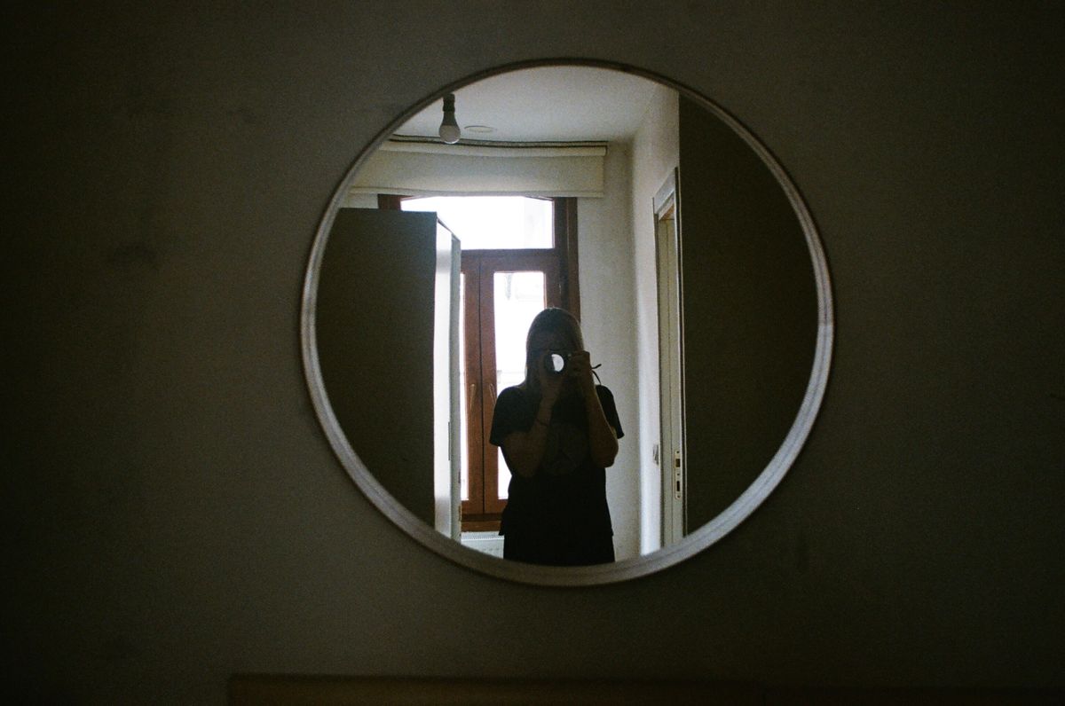 Creative circular mirror selfie framing interior hallway doubling viewer perspective like folklore portal motifs