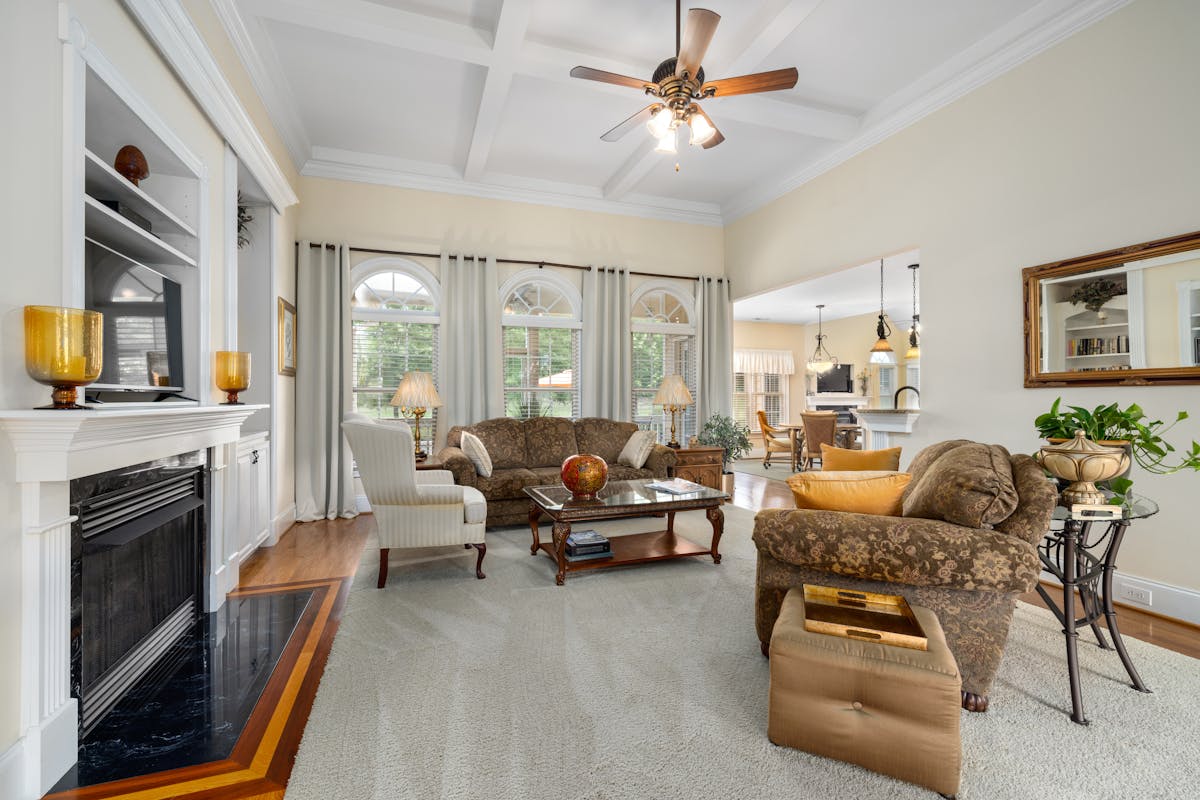 Spacious living room with a fireplace and elegant furnishings, illustrating where to place a large mirror