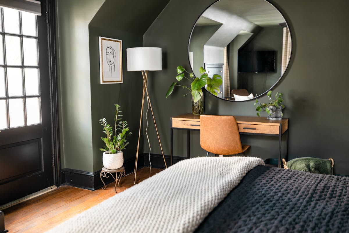 Cozy bedroom with soft green walls and natural light, illustrating the renewing feng shui Wood element