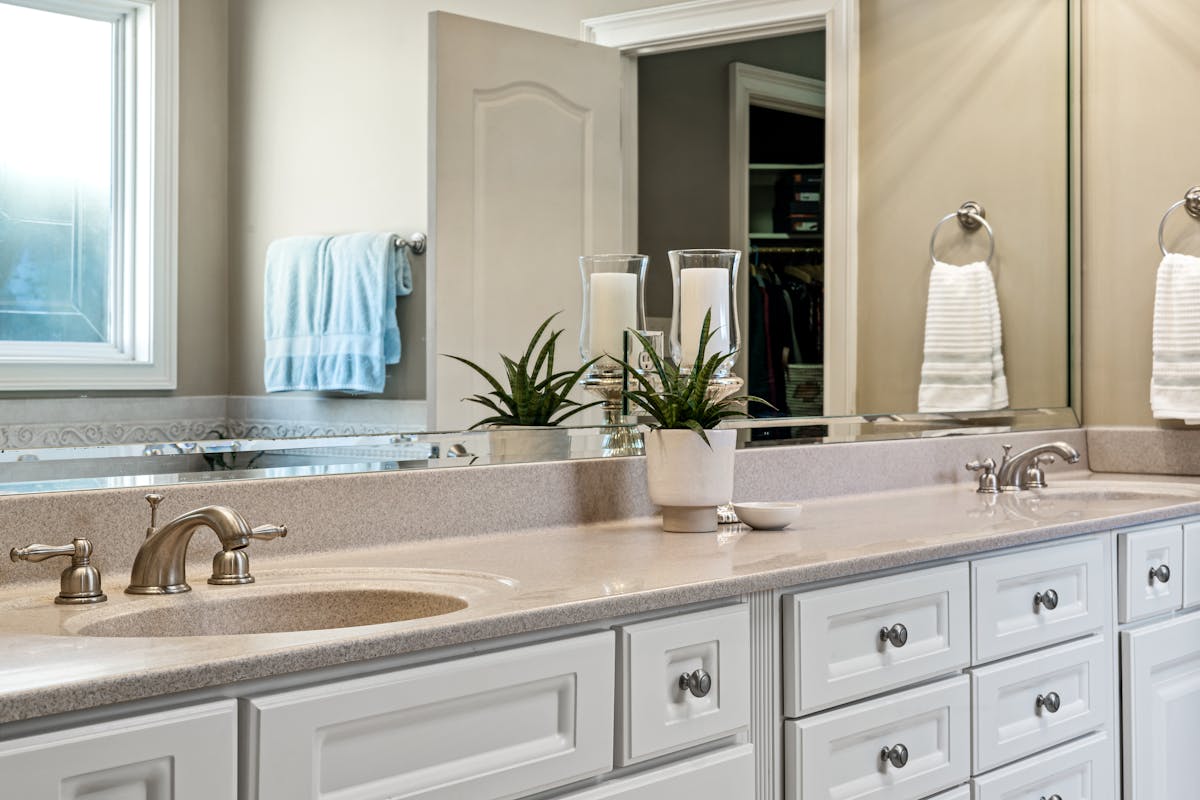 Modern bathroom vanity mirror illustrating how to size a vanity mirror to the vanity Modern bathroom with white cabinets and a large vanity mirror, illustrating how to size a vanity mirror