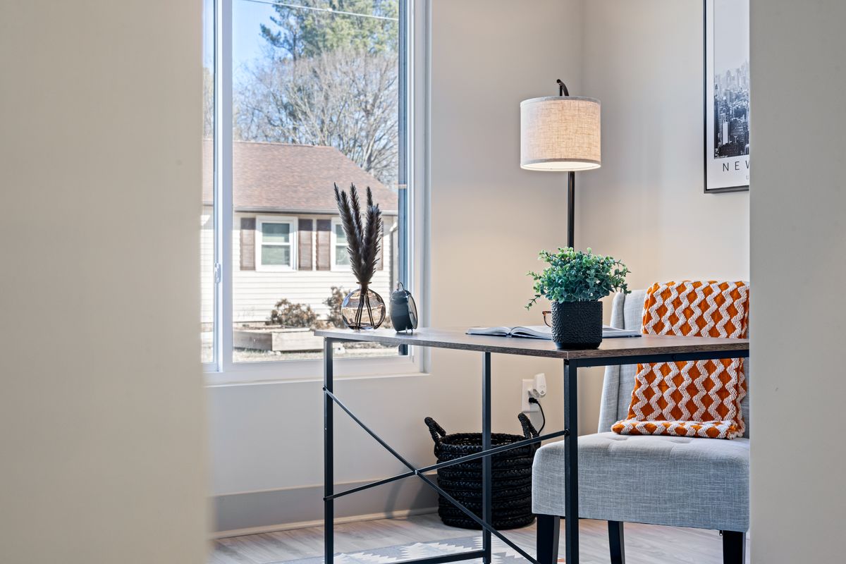 Desk facing a window illustrating a feng shui office layout placement to avoid Bright home office with a minimalist desk placed directly in front of a window, illustrating feng shui desk mistakes