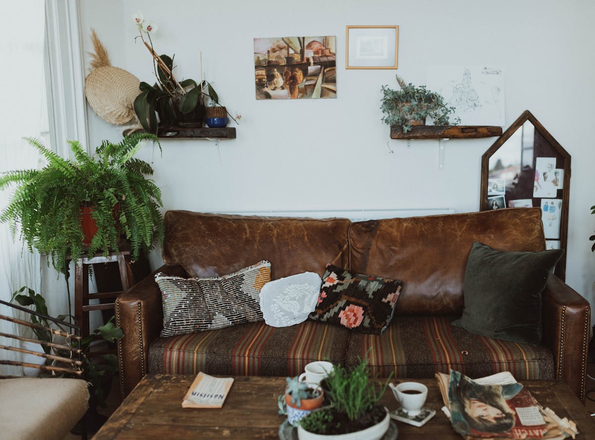 Cozy living room with a leather sofa, plants and warm rustic tones, illustrating grounding feng shui earth colors