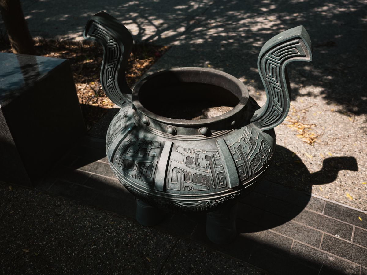 Sunlit decorative bronze vessel with intricate carvings representing the story of the women of Israel who donated bronze mirrors to build the sacred tabernacle basin in Exodus 38:8