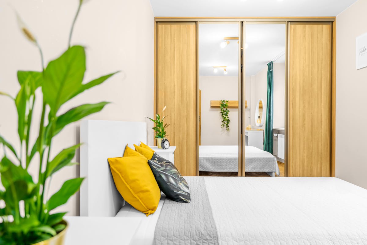 Mirrored closet beside a bed showing the placement rule for a wardrobe mirror Bedroom with a mirrored closet beside the bed illustrating where a wardrobe mirror should face