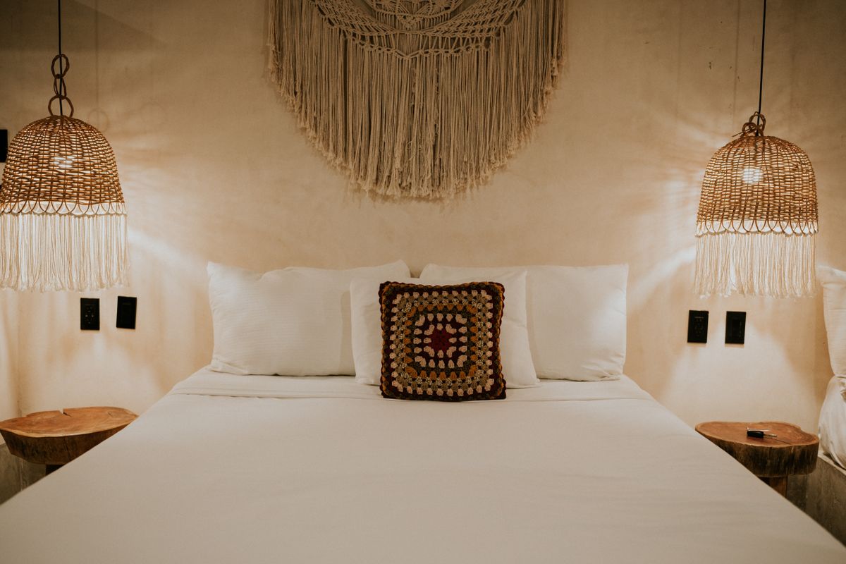 Bedroom with a macrame wall hanging illustrating woven texture for bedroom walls Bohemian bedroom with a macrame wall hanging and woven decor, illustrating texture in bedroom wall decor