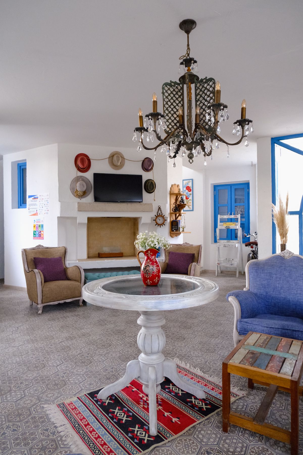 Elegant Mediterranean-influenced living room with chandelier and warm natural light