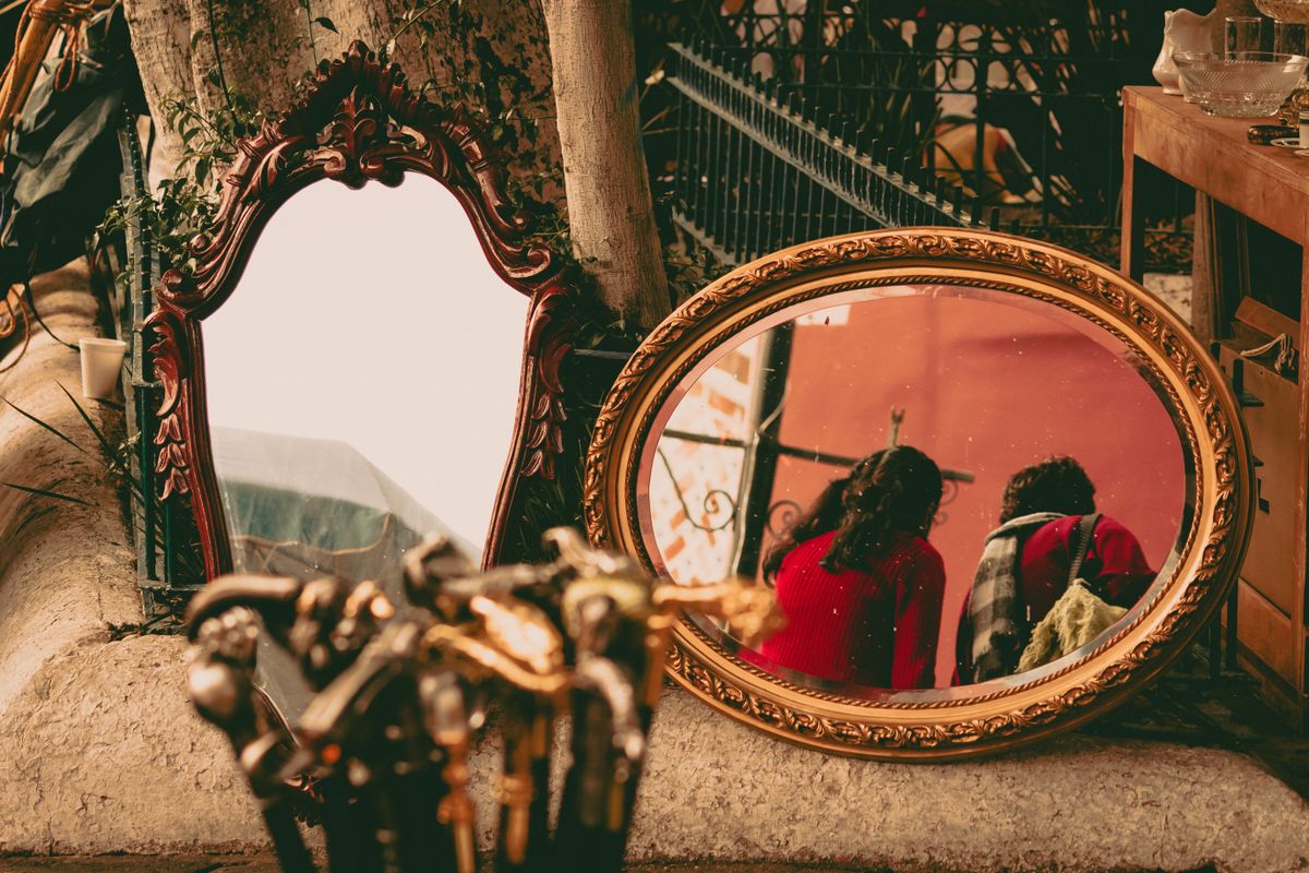 Ornate vintage mirrors at an outdoor market, representing mirror symbolism in different cultures around the world.