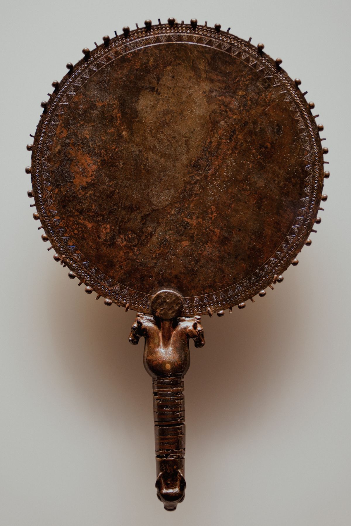 Ornate bronze hand mirror representing ancient mirrors and soul symbolism history Decorative bronze hand mirror with ornate handle evoking ancient mirror craft and historical spiritual beliefs