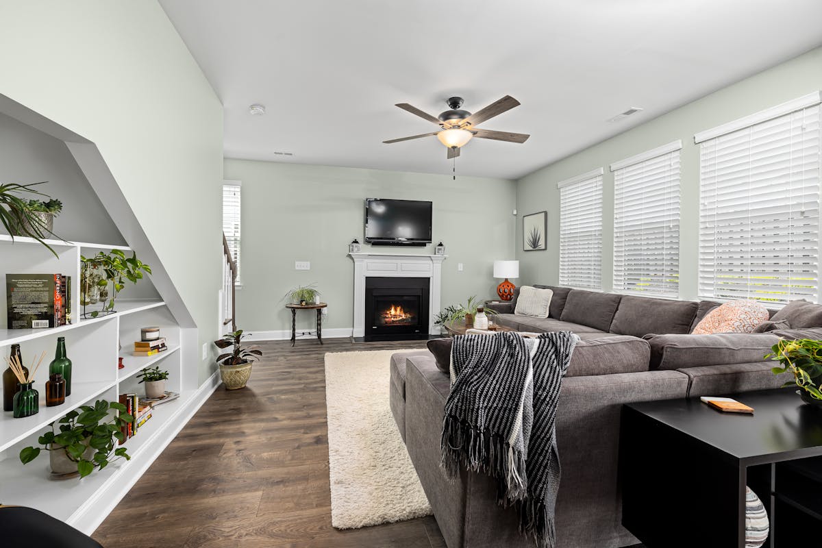 Sectional sofa forming a U-shaped seating area illustrating feng shui couch arrangement Living room with a large sectional sofa, fireplace and plants forming a U-shaped seating area, illustrating feng shui