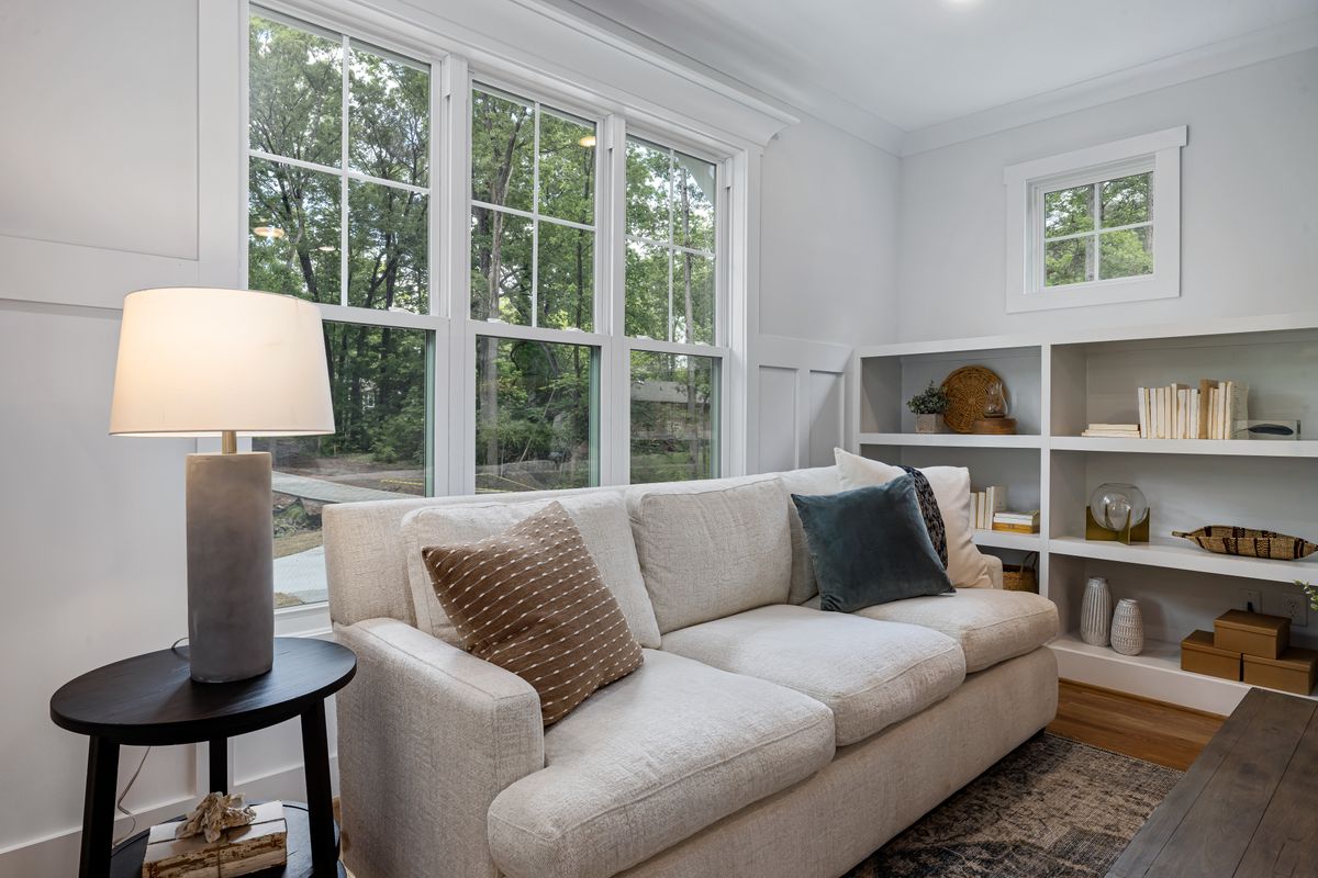 Sofa with a clear view of the room illustrating the feng shui command position for a couch Cozy living room sofa near large windows with a clear view of the room, illustrating the feng shui command position