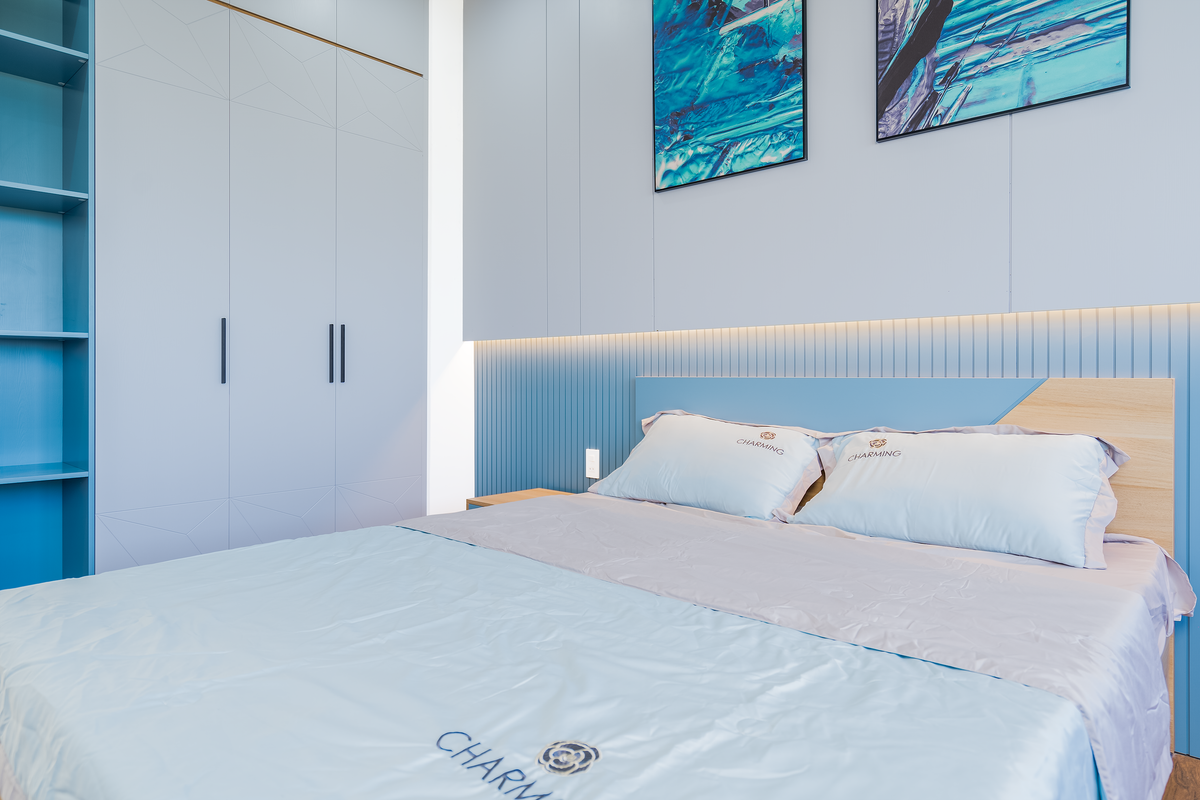 Elegant bedroom with soft blue accents and a cozy bed, illustrating the calming feng shui Water element