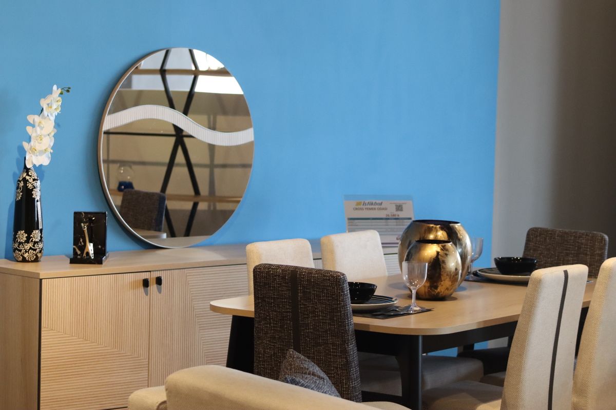 Round mirror in a minimalist dining room illustrating shape and size choices for mirrors for a dining room Sleek dining room with a round mirror on the wall showing the best mirror shape for a dining room
