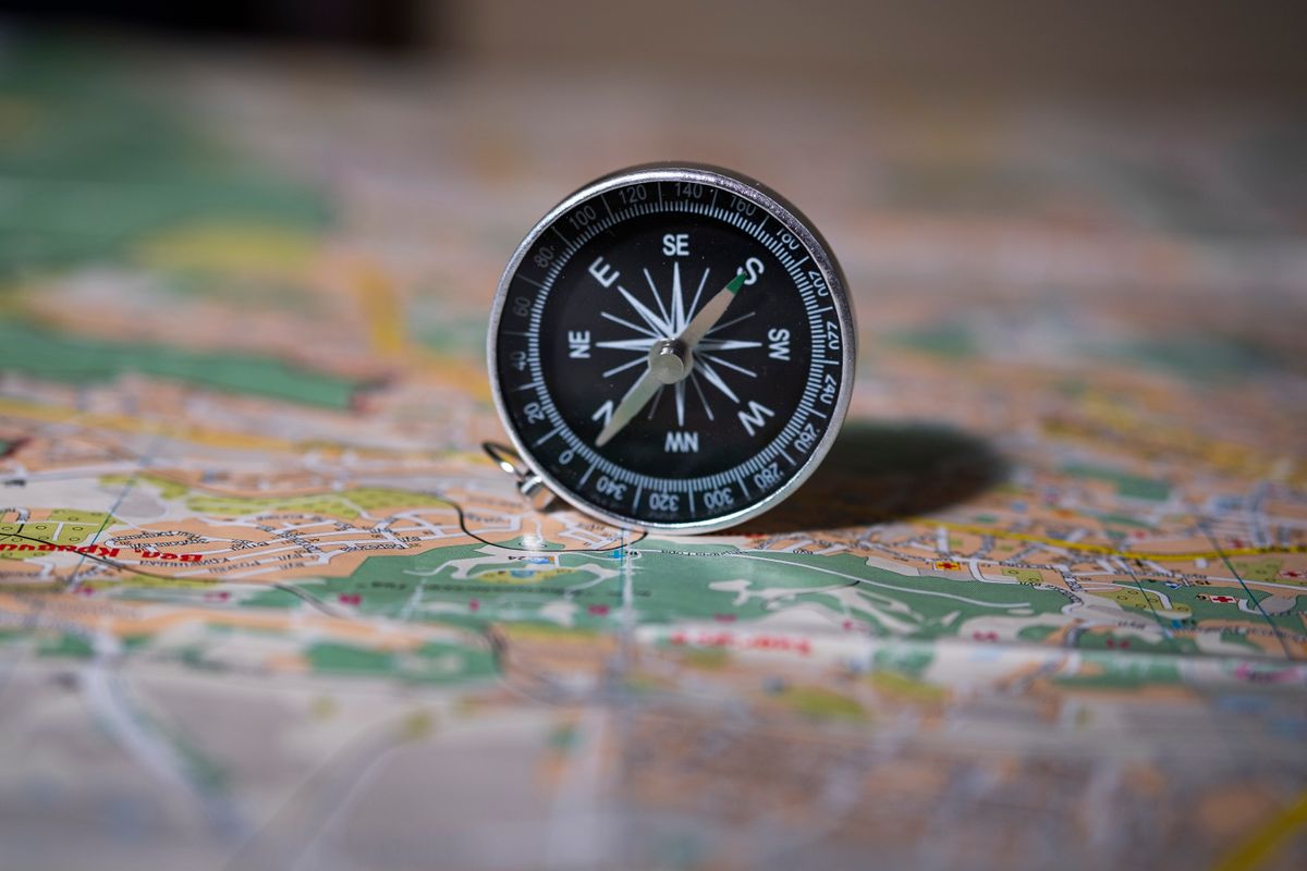 Black compass resting on a detailed map, illustrating compass directions for feng shui sleeping direction