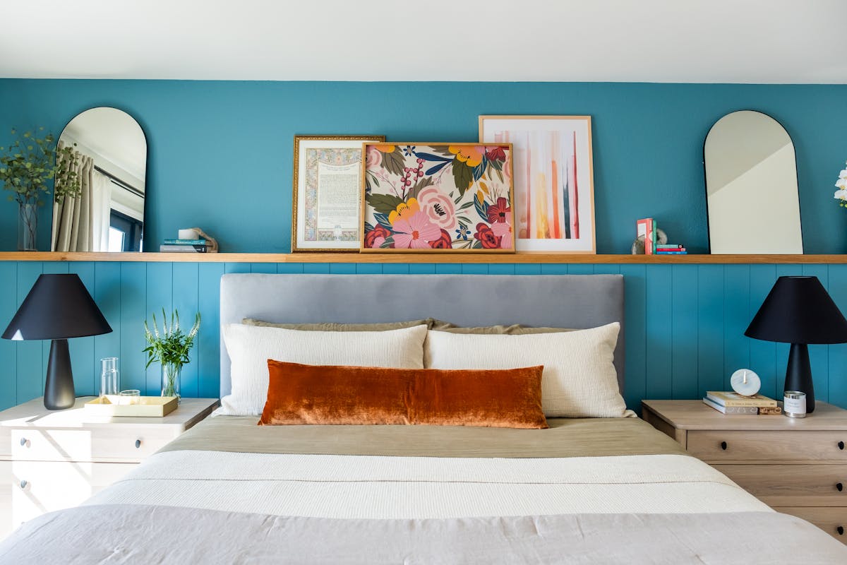 Round mirrors and artwork styled above a bed as mirror above bed decor ideas Bright bedroom with round mirrors and artwork arranged above the bed as mirror above bed styling ideas