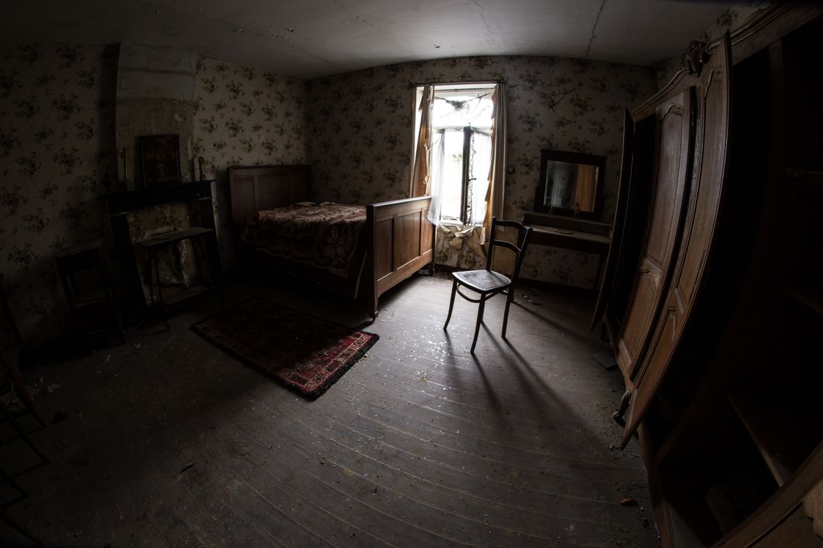 Dark atmospheric bedroom with vintage furniture and moody atmospheric lighting suggesting a mysterious night setting