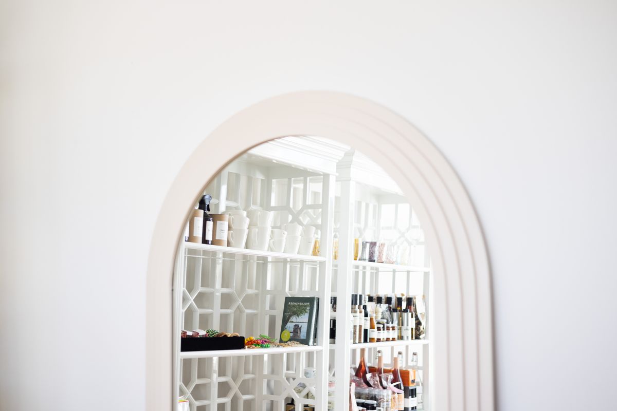 Arched doorway in a minimalist interior illustrating why an arched mirror reads as architecture Minimalist interior with an arched doorway and modern white shelves, illustrating why an arched mirror wall works