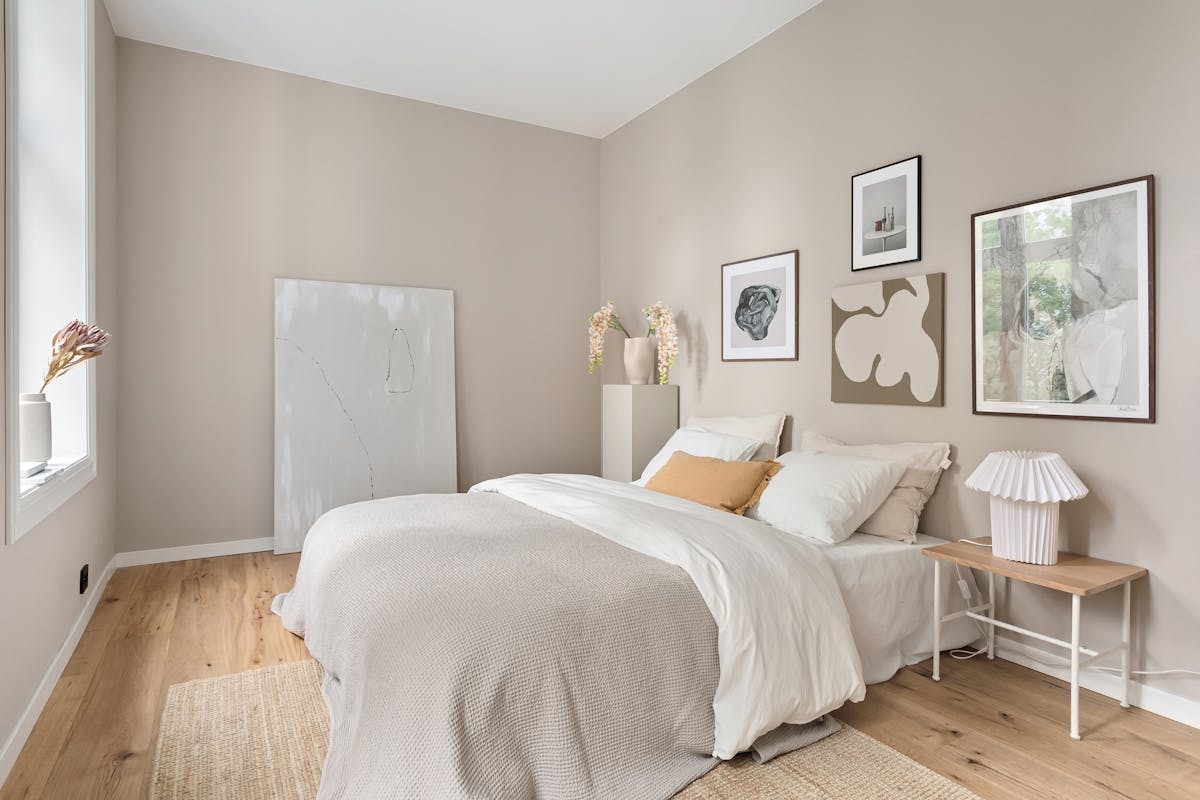 Serene minimalist bedroom in soft neutral tones with modern art, illustrating how color shapes feng shui energy