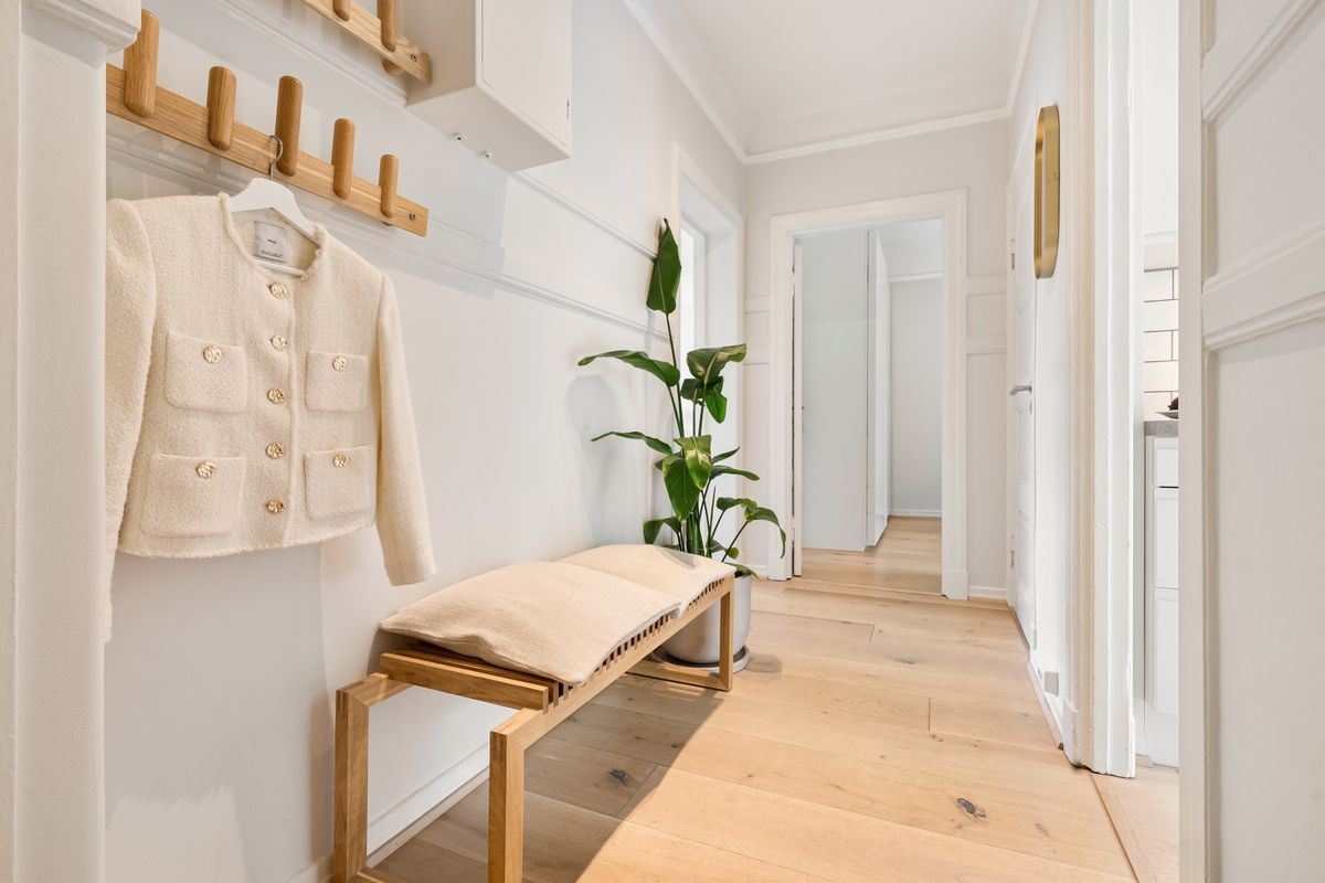 Bright minimalist hallway with wooden furniture and a coat area, showing entryway mirror with hooks styles
