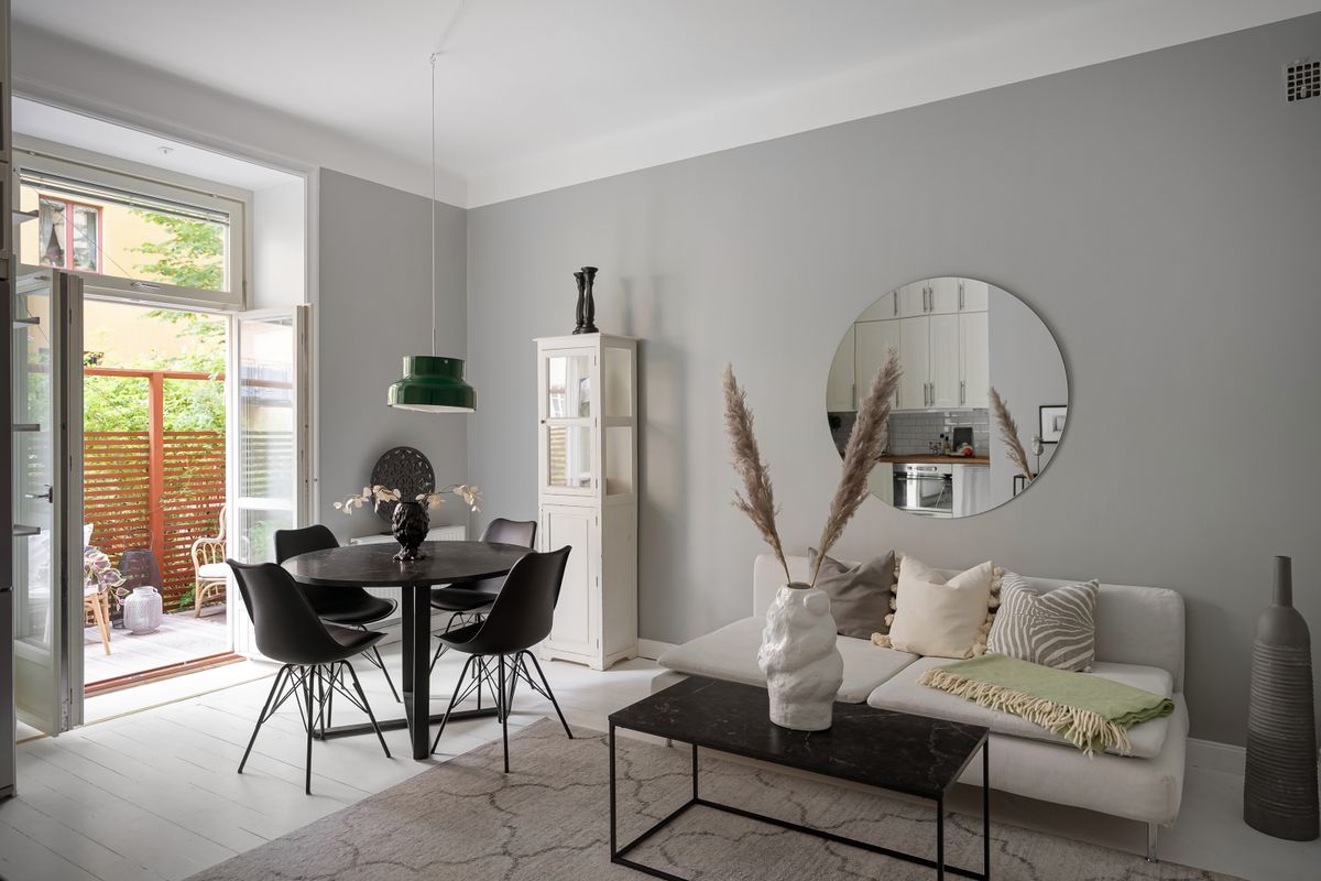 Round mirror above a dining table as a stylish dining room mirror idea Dining room with a round mirror above a black dining table as a dining room mirror idea