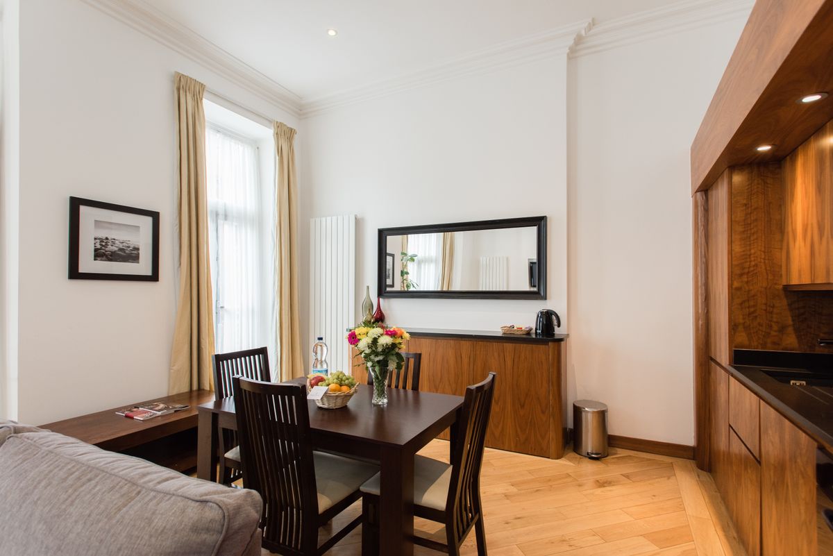 Modern dining room where a large heavy mirror needs secure stud-anchored hanging Modern dining room with wood furniture where a large mirror must be hung securely