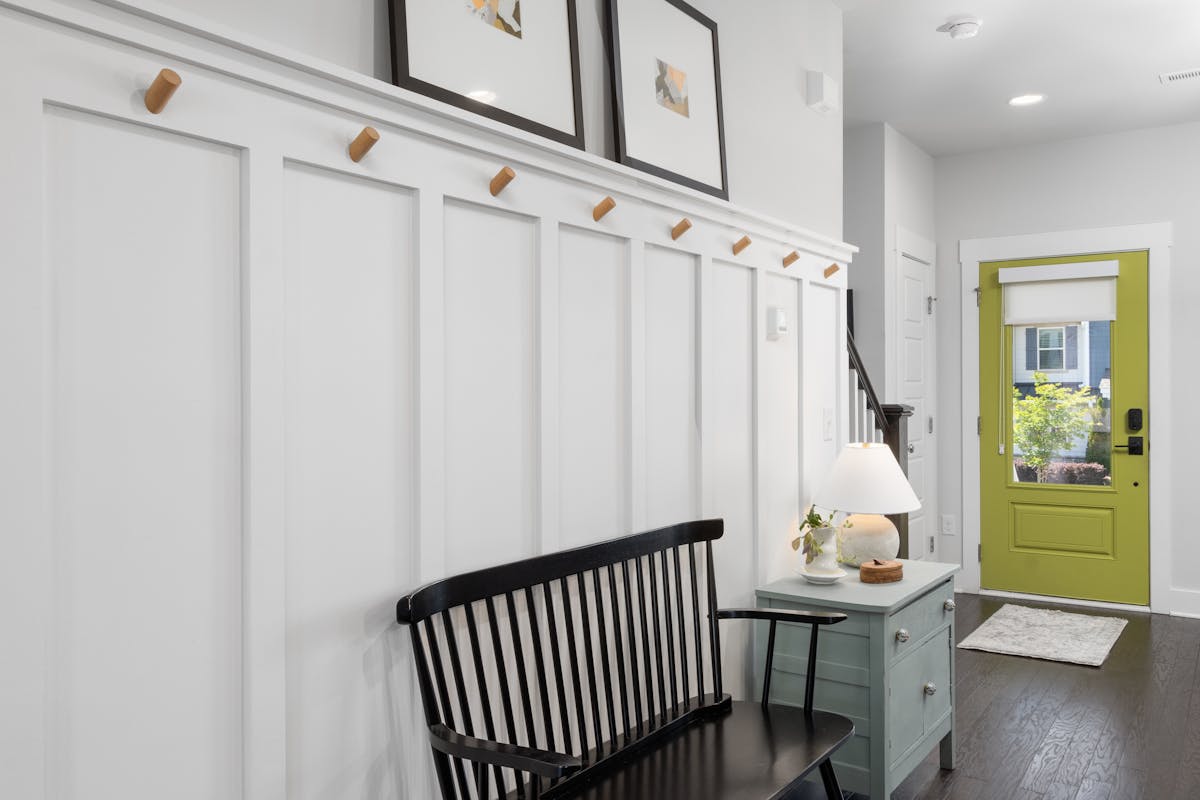 Stylish entryway with a green door, bench, and decor, showing how to style an entryway mirror with hooks