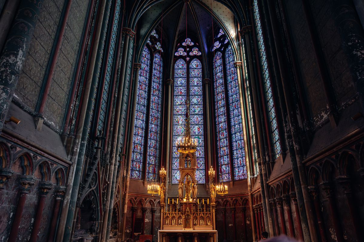 Gothic architecture and stunning stained glass windows in a historic cathedral in Amiens representing the transforming vision of God glory described in 2 Corinthians 3:18