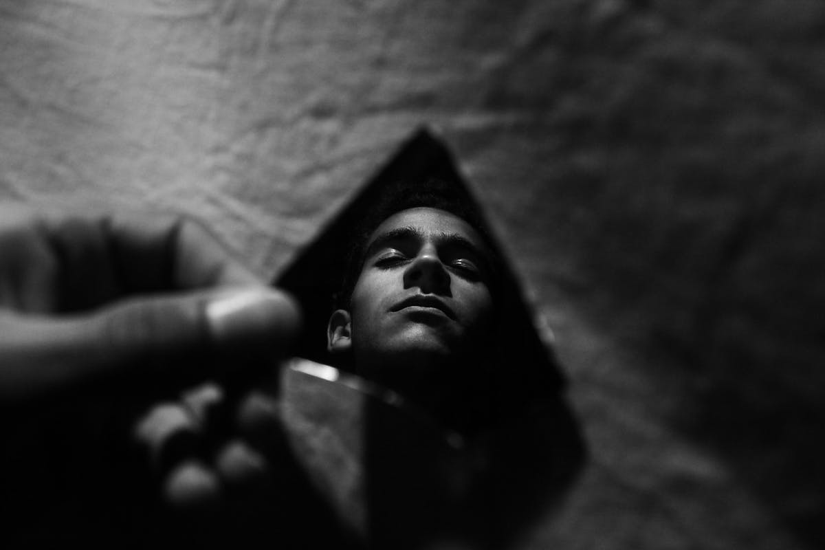 Moody black and white reflection captured in a broken piece of glass representing the broken mirror spiritual meaning as a possible sign or omen