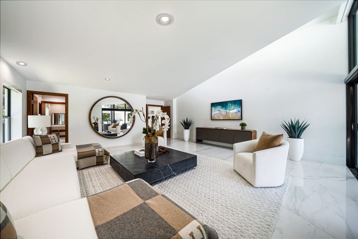Spacious modern living room with a large wall mirror and elegant furnishings, illustrating why extra large mirrors work