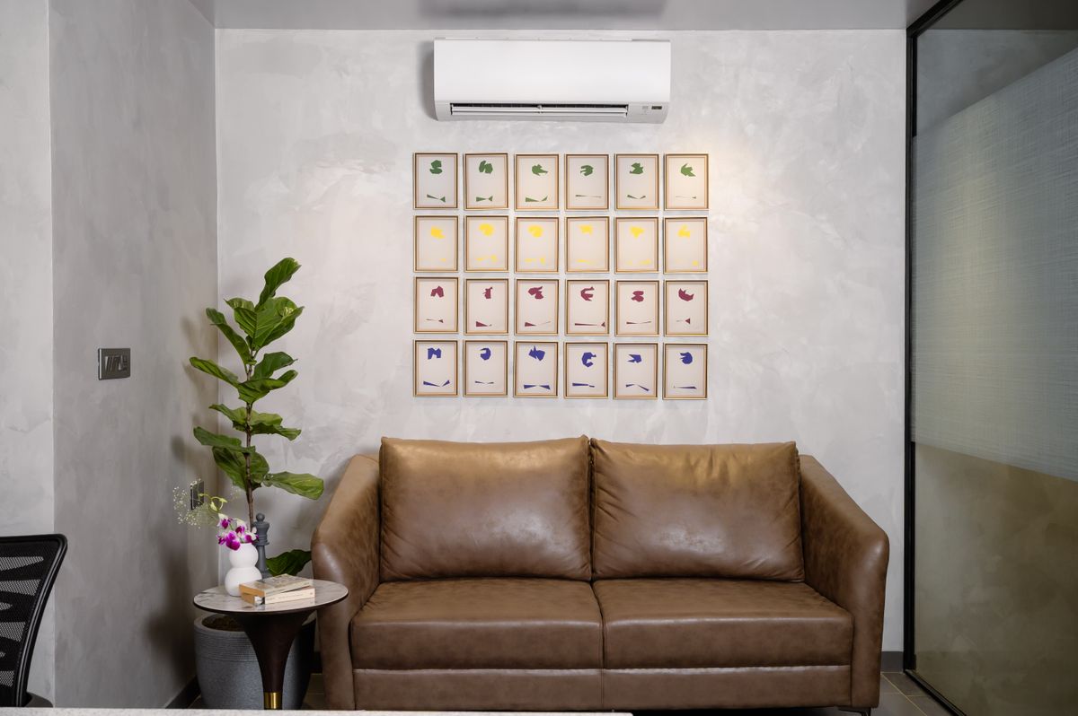 Living room wall art above a sofa illustrating how to size magnolia wall art to furniture Living room with a brown sofa, wall art and a potted plant, illustrating how to size magnolia wall art above furniture