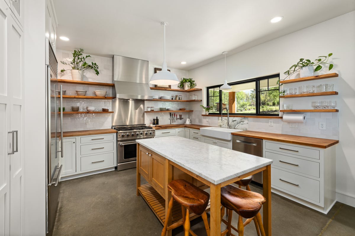 Bright modern kitchen with open shelves and wall space, illustrating where to hang metal wall art in a kitchen