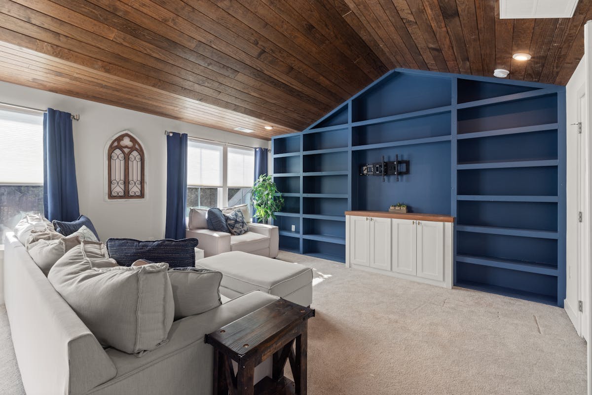 Living room with blue built-in shelves and a beige sofa, illustrating a shelving accent wall