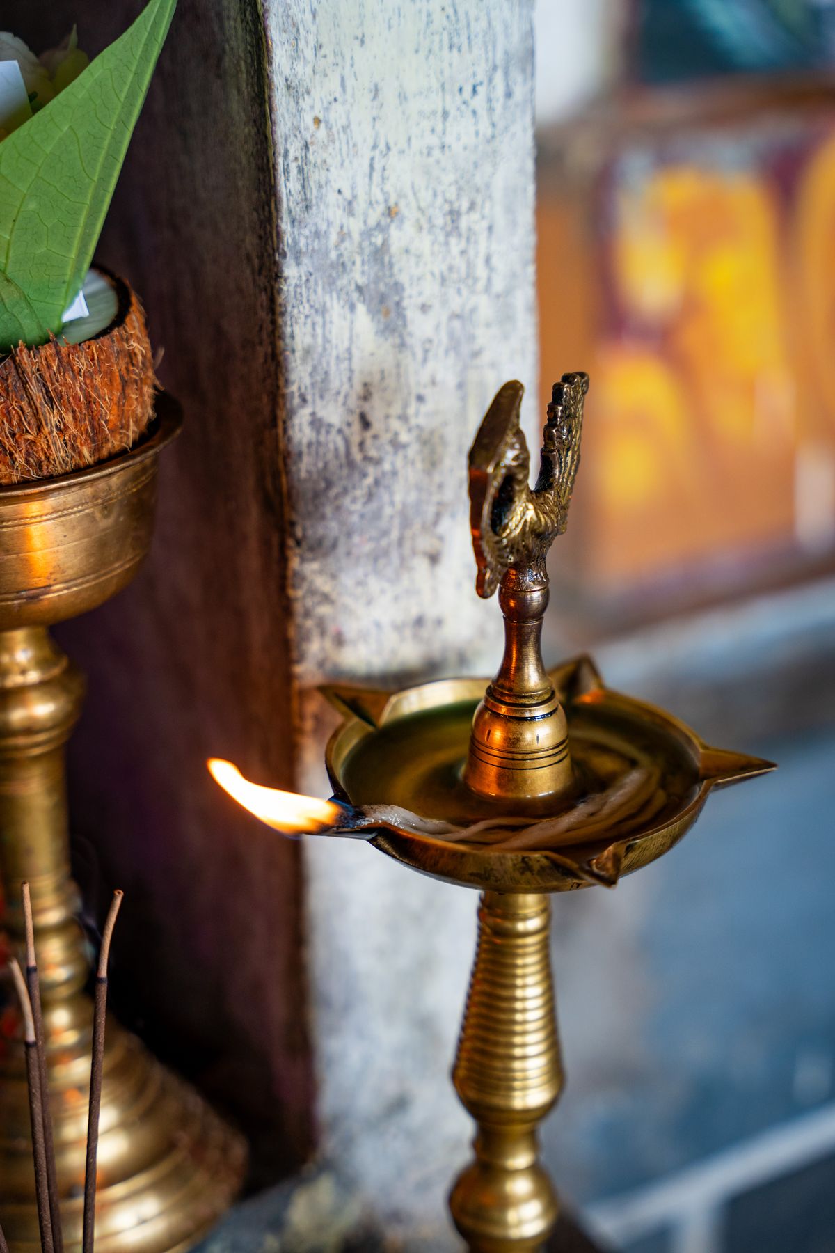 Brass temple lamp in Hindu tradition evoking the sacred ritual context of the Darpana offering Lit brass oil lamp in a Sri Lankan temple showcasing Hindu ritual tradition evoking the sacred atmosphere of Darpana and puja