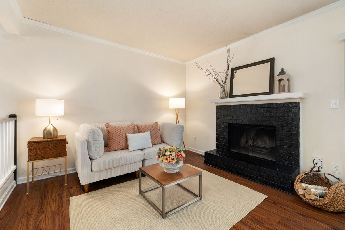 Living room with black accents illustrating black wall mirrors over a fireplace or console Living room with a black brick fireplace and stylish decor, illustrating black wall mirrors in a living room