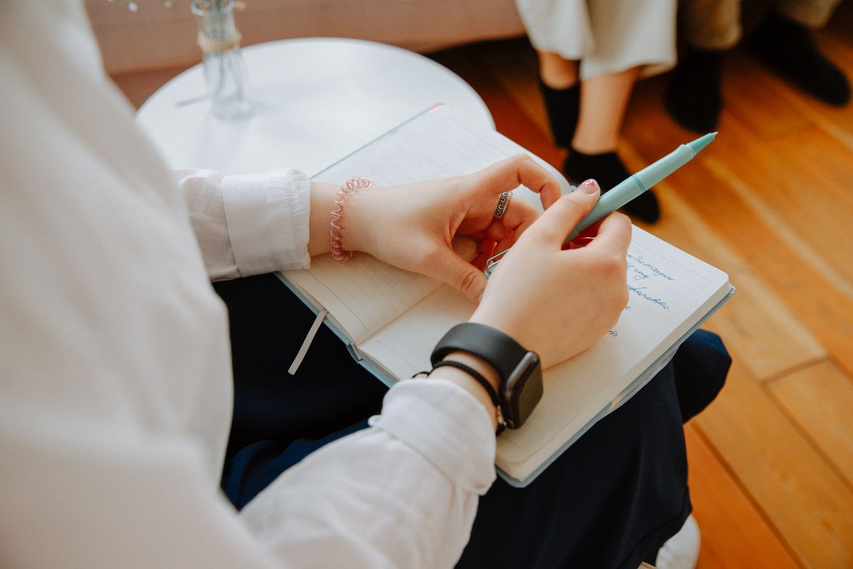 Hands taking notes on a clipboard during a mental-health session representing how the fear of mirrors is assessed and diagnosed