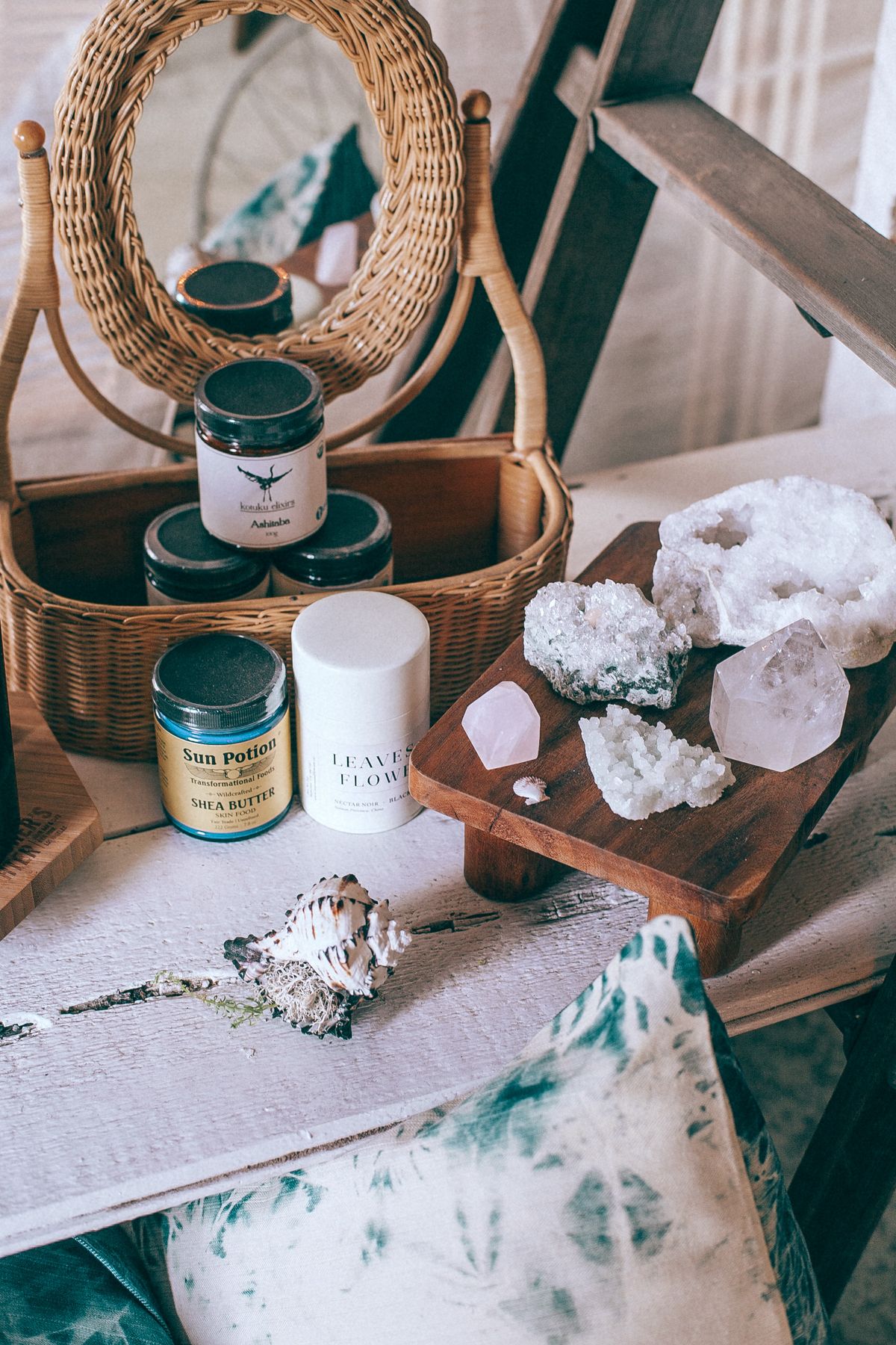 Crystals seashells and jars reflected in mirror for spiritual practice still life Crystals and beauty jars in wicker basket reflected in mirror beside seashells suggesting spiritual cleansing and mirror altar practice