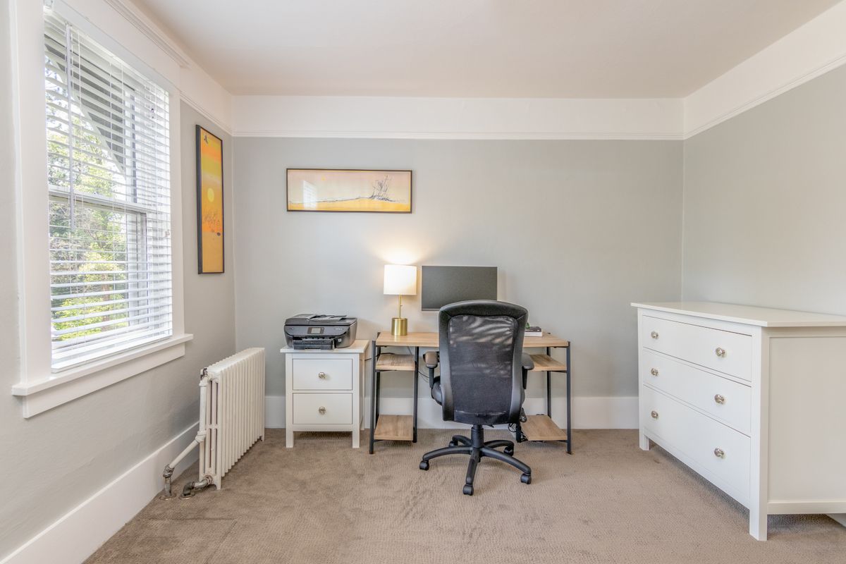 Home office desk illustrating the command position in a feng shui home office setup Bright simple home office with sleek furniture, illustrating the desk command position in a feng shui home office