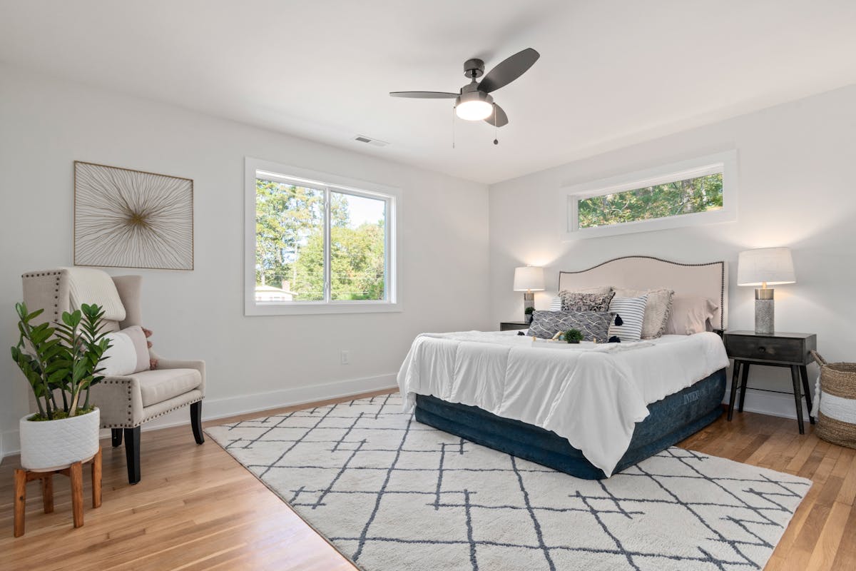 Bright, cozy bedroom with a bed beneath a window and natural light, illustrating the feng shui bed under window question
