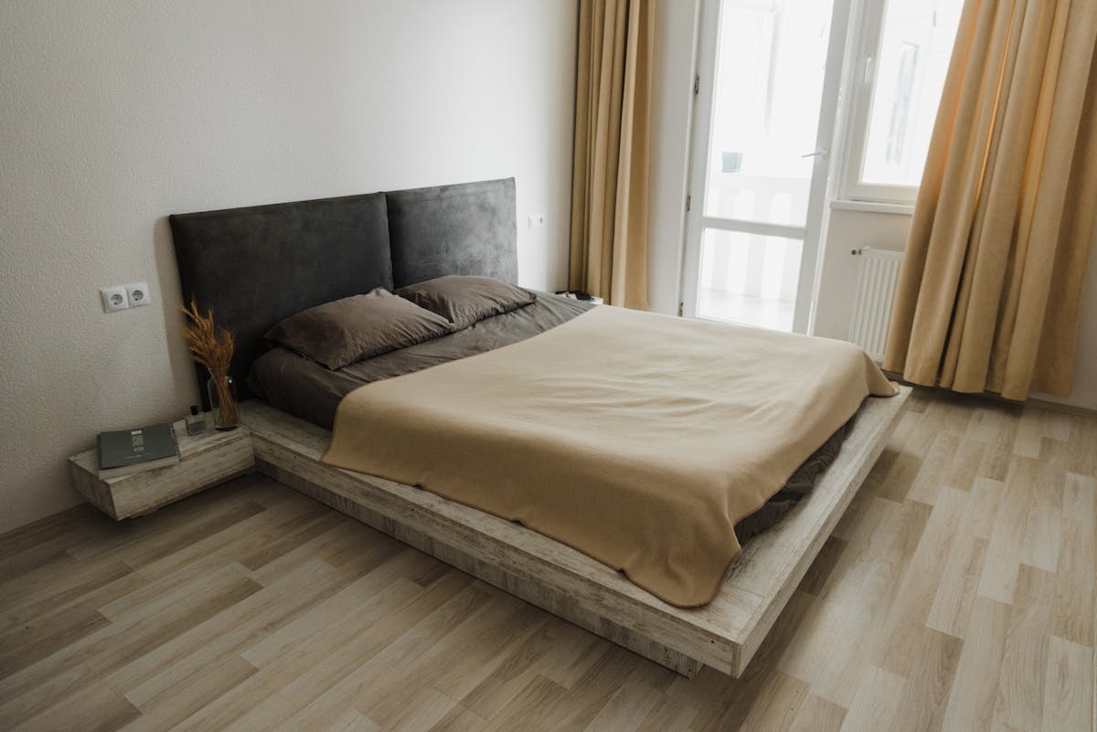 Uncluttered bedroom with clear pathways illustrating feng shui energy flow Clean, uncluttered minimalist bedroom in neutral tones with clear floor space, illustrating feng shui energy flow