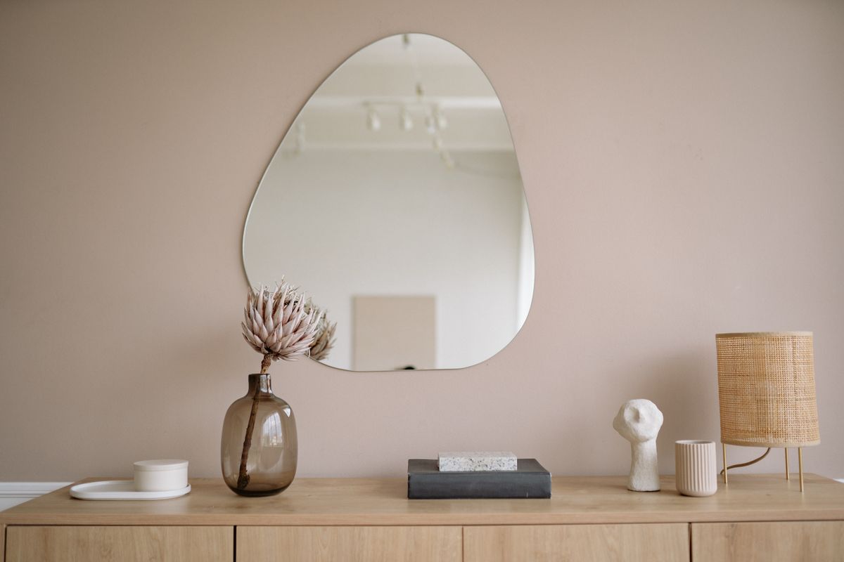 Styled minimalist interior illustrating where to place a full length mirror Stylish minimalist interior with a mirror, decorative vase, and lamp, illustrating where to place a full length mirror