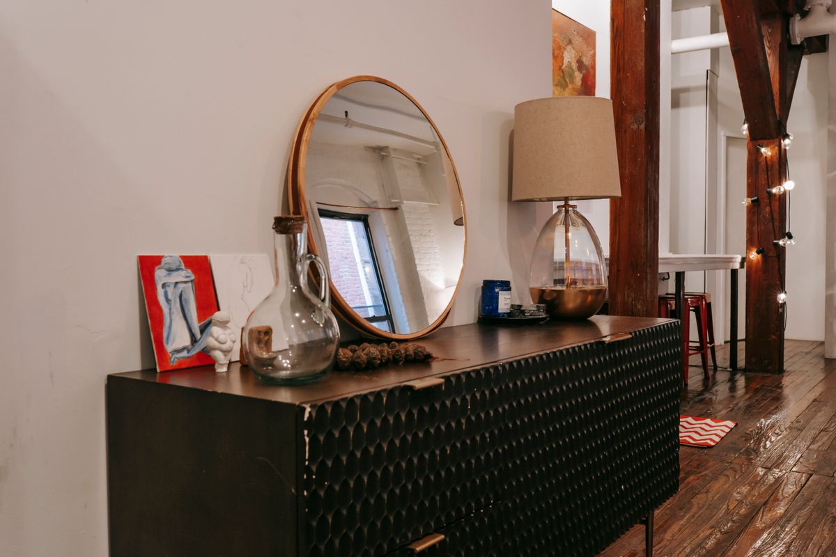 Chest of drawers with a mirror above it illustrating dresser mirror hanging height Black chest of drawers with a mirror above it showing how high to hang a mirror over a dresser
