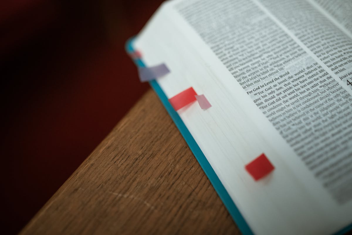 Open Bible with colorful bookmarks on a wooden desk representing the practical daily application of the mirror of Scripture for spiritual self-examination and transformation