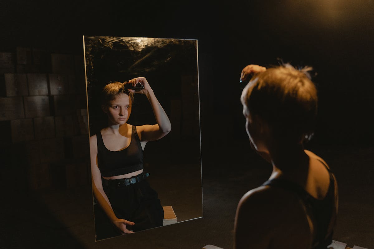 Person gazing into a mirror in a dimly lit space creating a contemplative and mysterious mood at night