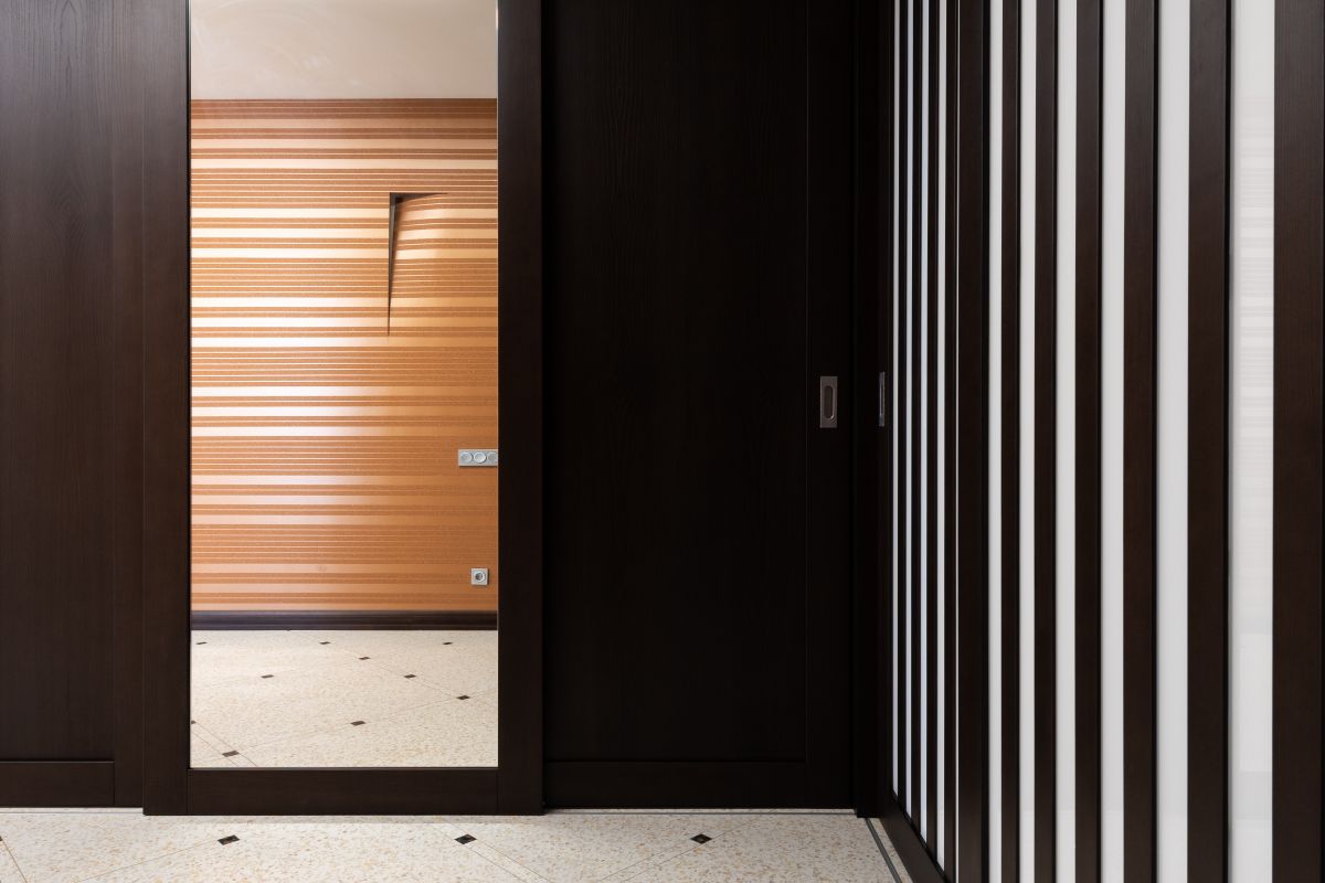Hallway with a reflective mirror on a dark side wall, showing why a side-wall hallway mirror works