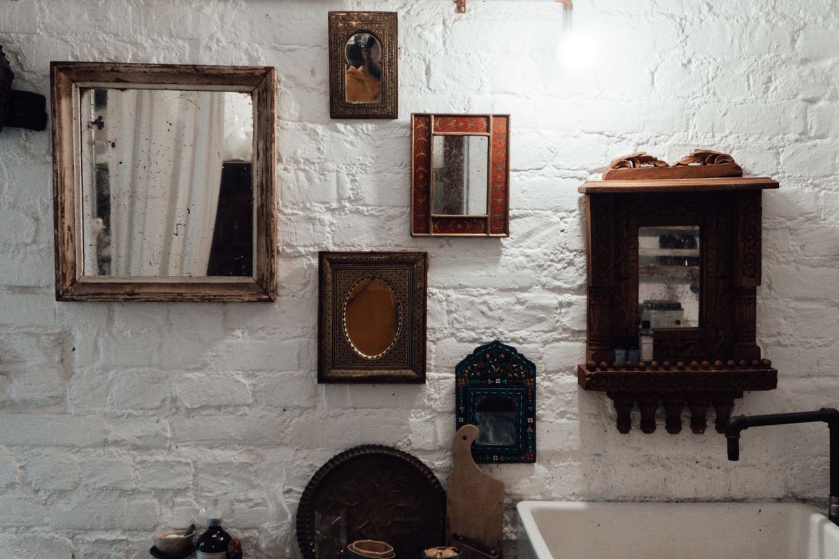 Aged antiqued mirrors illustrating antiqued and smoked mirror wall panels for a living room Aged antique mirrors in decorative frames on a textured wall, illustrating antiqued mirror wall panels