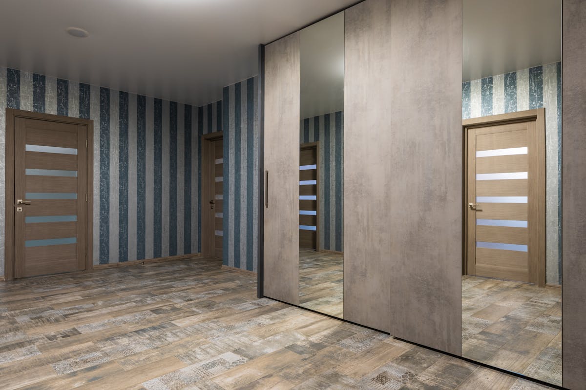 Mirrored wardrobe with sliding doors reflecting a bright bedroom, illustrating full-length wardrobe mirror ideas.
